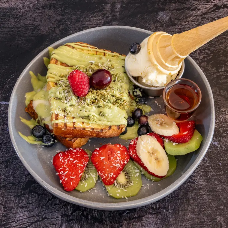 Baked brioche French toast under vanilla mascarpone, with berries and a cone of ice cream.