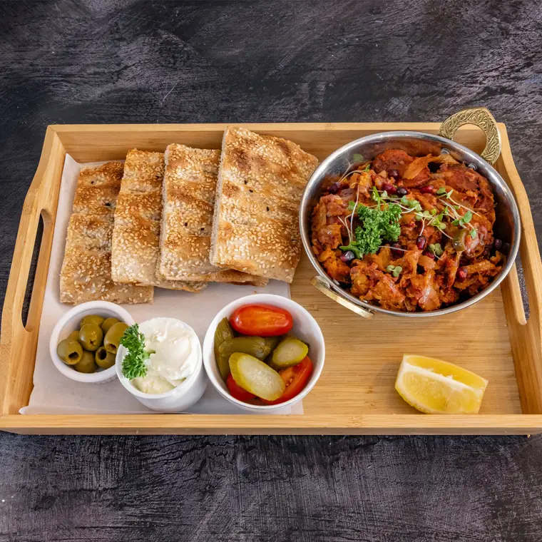 Bandari lunch tray — spicy sausage and potato with flatbread, pickles and yoghurt.