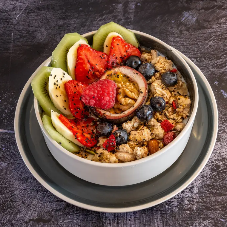 Granola bowl with strawberries, blueberries, kiwi and banana.