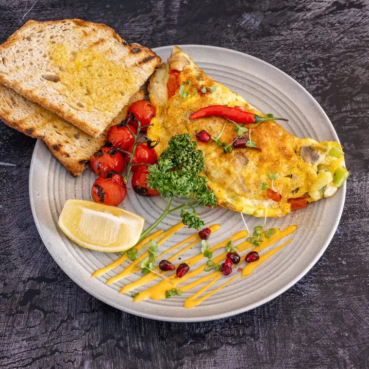 Veggie omelette with cherry tomatoes, broccoli and toast.