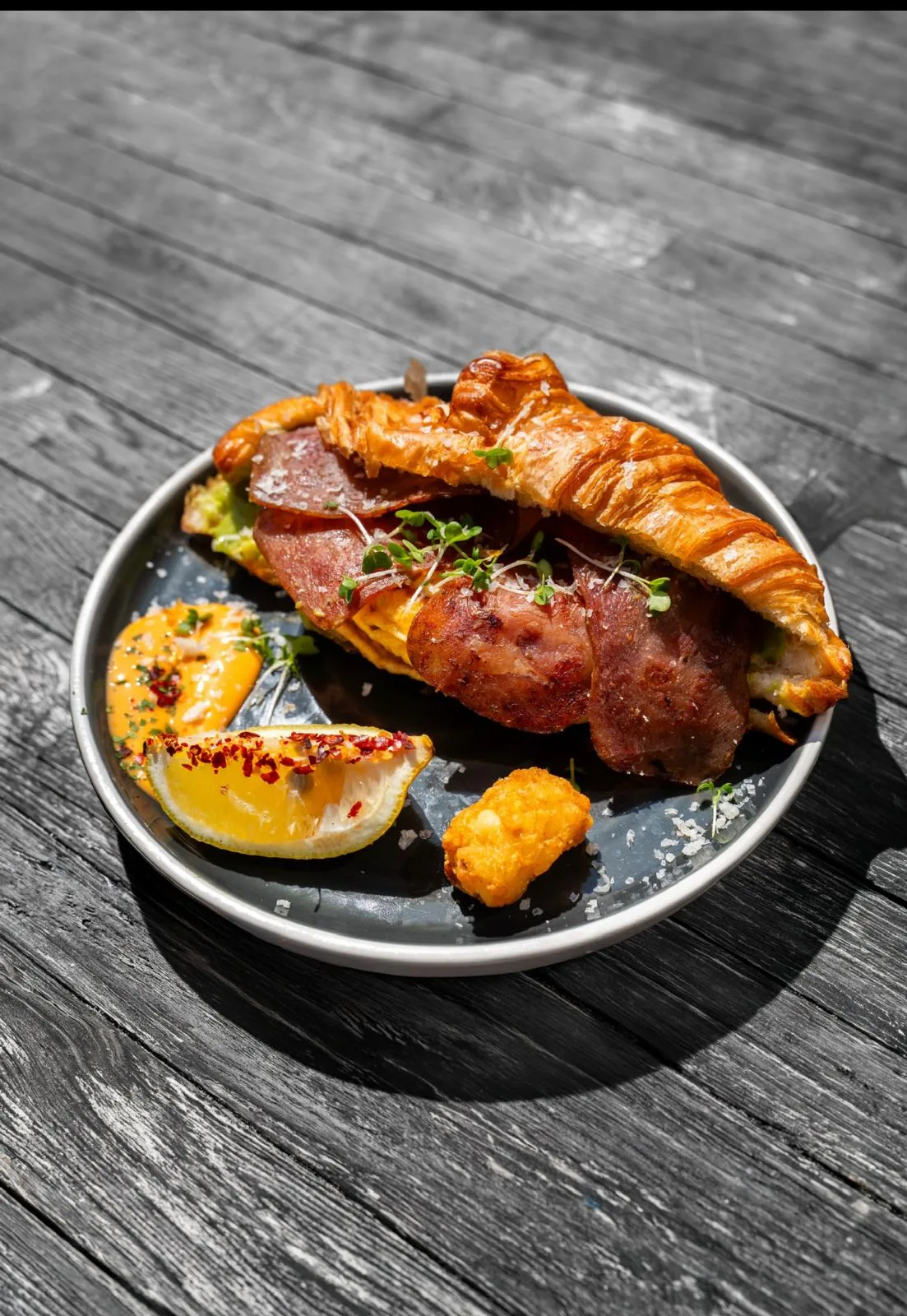Breakfast croissant at TenTen, stuffed with turkey rashers, egg and avocado, dusted with sea salt and served with a hash brown, chilli mayo and a lemon wedge.